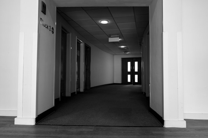 A dark lobby beneath a Block 3 sign, glazed double doors at the far end.
