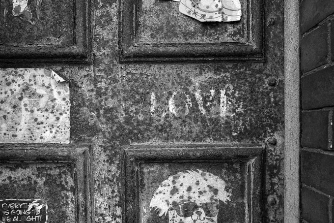LOVE, in stencil, on a rusting door. Faded but still very legible.
