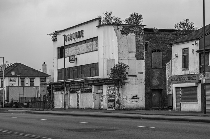 The New Osborne frontage on Oldham Road, the entrance canopy at street level, Hollywood Wines to the right.