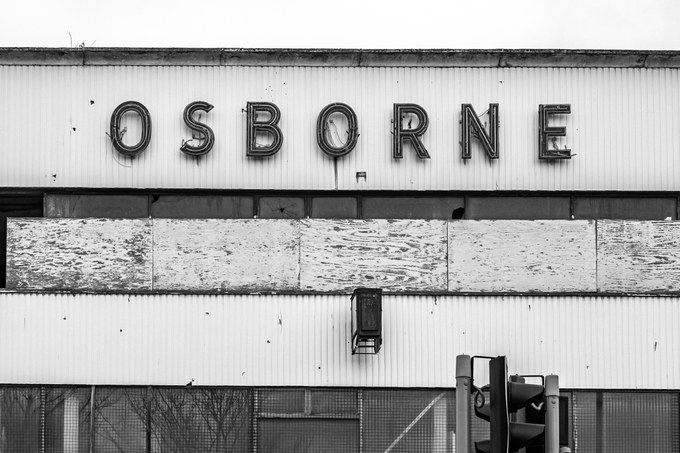 Close view of the OSBORNE letters along the top of the frontage above a boarded panel.
